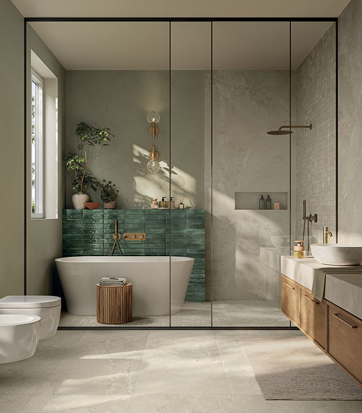 Salle de bains contemporaine avec des surfaces des collections Revel Dune, Mosaico Dune et Workshop Jade, caractérisée par une baignoire îlot, un mur vert brillant, une grande douche vitrée, un meuble vasque en bois et une lumière naturelle qui met en valeur les surfaces aux tons neutres.