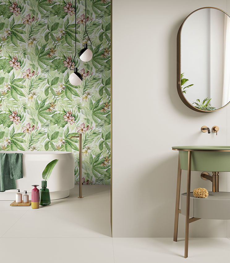 Salle de bains moderne avec mur décoré de motifs tropicaux, baignoire îlot blanche et lavabo vert avec miroir ovale.