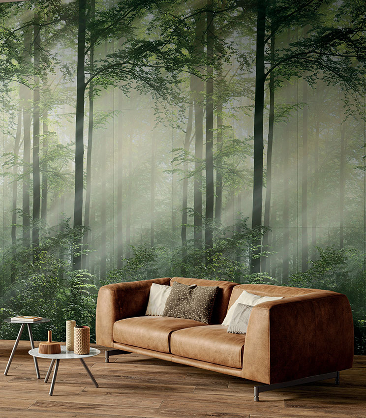 Salon avec canapé en cuir et spectaculaire revêtement céramique en dalles fines effet wallpaper représentant, avec un réalisme photographique, une forêt