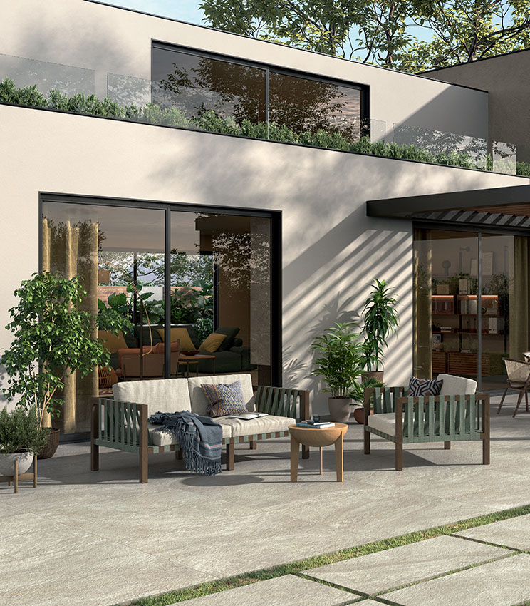 Spazio outdoor arredato con pavimentazione effetto pietra The Place di Panaria Ceramica, dall’eleganza naturale e contemporanea.