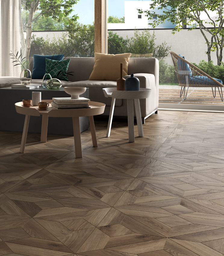 Vue d'un salon avec de grandes baies vitrées et deux grands canapés, avec un sol en grès cérame effet bois de couleur sombre revisitant la pose à caissons.